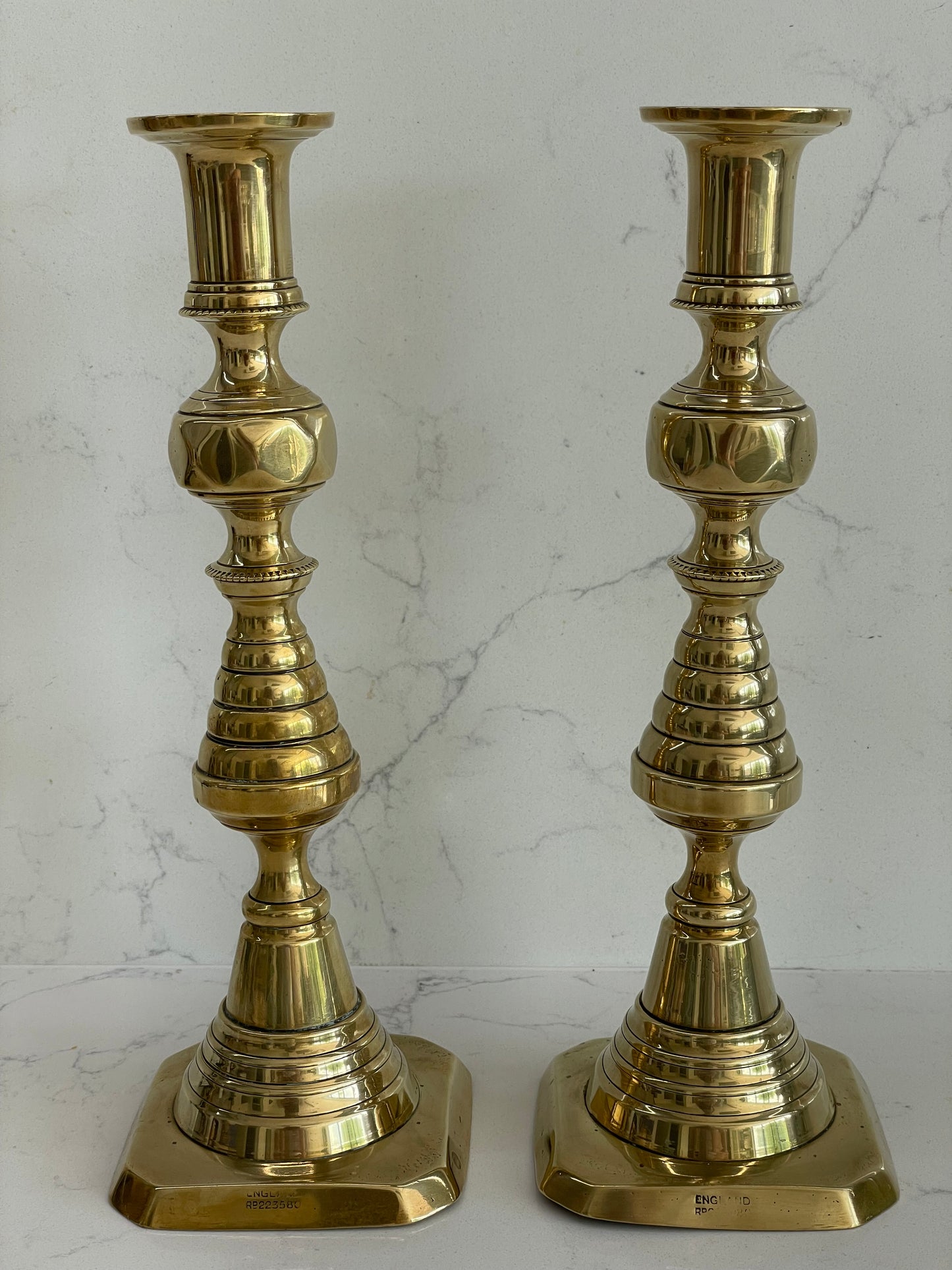 Unique pair of antique English Victorian 19th Century brass candlesticks stamped with Registration Design 223580 with 2 matching 100% London Beeswax candles