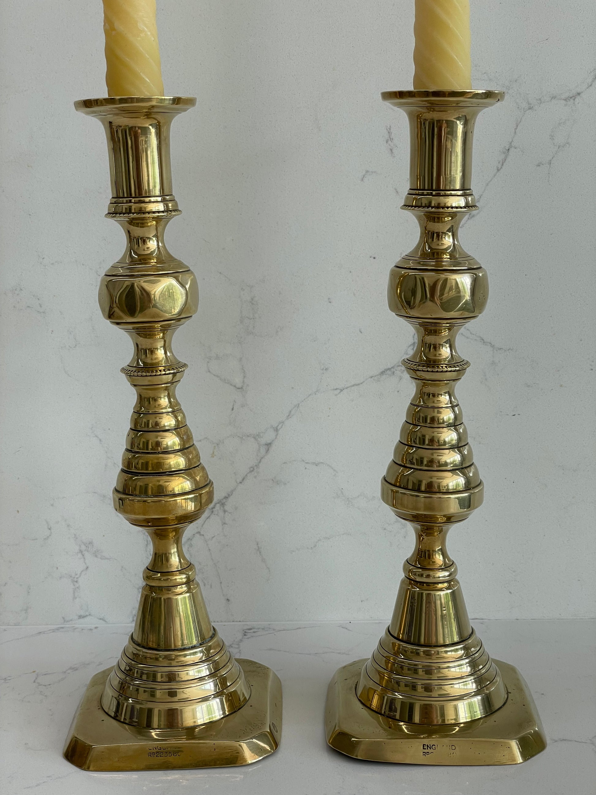 Unique pair of antique English Victorian 19th Century brass candlesticks  stamped with Registration Design 223580 with 2 matching 100% London Beeswax